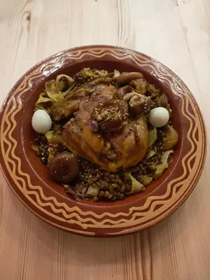 a plate of food with a chicken and beans at Riad Bianca Marrakech in Marrakech