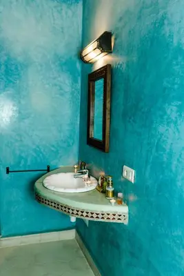 a blue bathroom with a sink and a mirror at Riad Bianca Marrakech in Marrakech