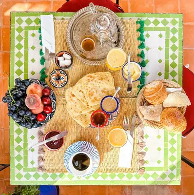 a table with bread and other foods on it at Riad Bianca Marrakech in Marrakech