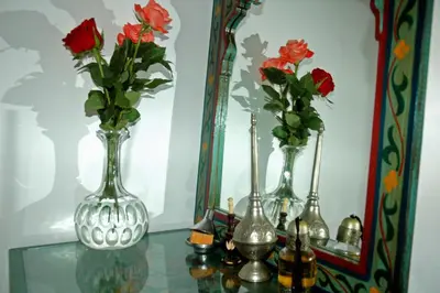 three vases sitting on a glass table in front of a mirror at Riad Blue Berber in Marrakech