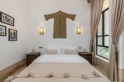 a bedroom with a bed with a cross hanging on the wall at Riad Louhou in Marrakech