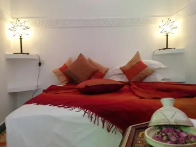 a bedroom with a red and white bed with pillows at Riad Mehdia & spa in Marrakech