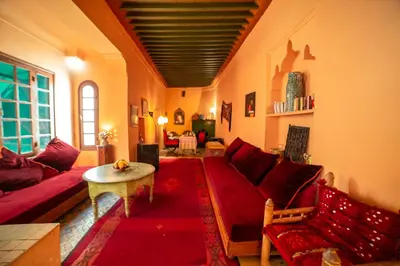 a living room with a red couch and a table at Riad Dar Marhaba in Marrakech