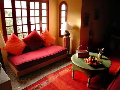 a living room with a red couch and a table at Riad Dar Marhaba in Marrakech