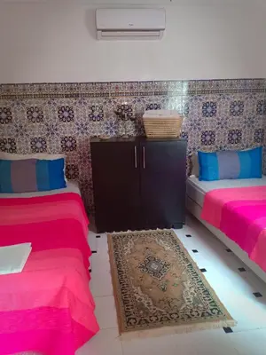 two beds in a room with pink and blue at Dar HAJAR in Marrakech