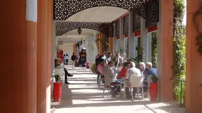 a group of people sitting at tables on a sidewalk at Riad Safae in Marrakech