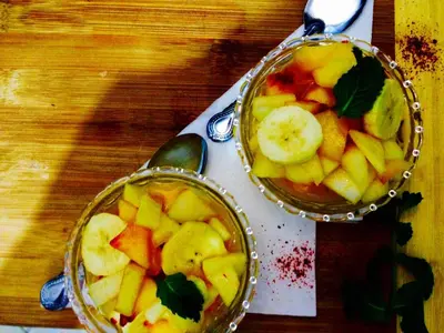 two bowls of fruit on a table with a spoon at Riad Jakoura in Marrakech