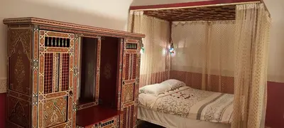 a bedroom with an ornate bed with a canopy at Riad Ifoulki in Marrakech