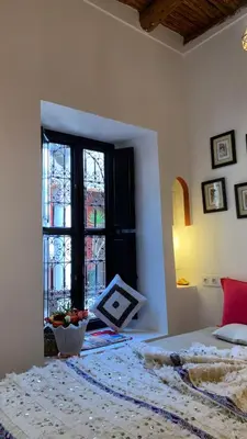 a bedroom with a bed and a large window at Riad Boussa in Marrakech