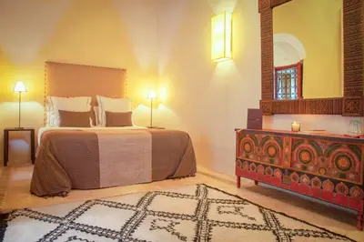 a bedroom with a bed and a dresser and a mirror at Riad Dar Karma in Marrakech