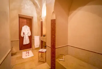 a bathroom with a robe hanging next to a door at Riad Dar Karma in Marrakech