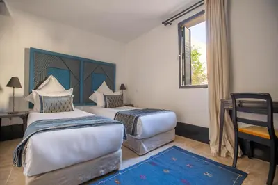 a hotel room with two beds and a window at Riad & Spa Azzouz in Marrakech
