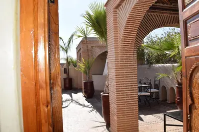 an outdoor patio with potted plants and an archway at Riad Granvilier in Marrakech