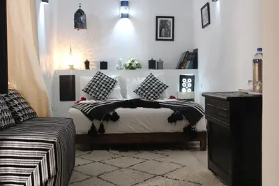 a bedroom with a bed with black and white pillows at Riad Alamine in Marrakech