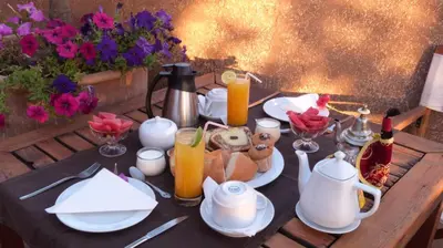 a table with plates and pitchers of orange juice and drinks at Riad Al Ksar & Spa in Marrakech