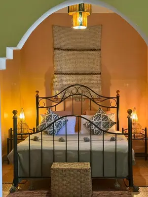 a bedroom with a bed with a chandelier at Riad Hotel Sherazade in Marrakech
