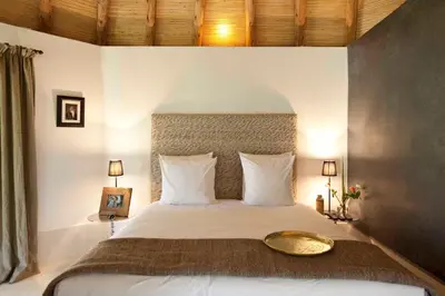 a bedroom with a large bed with white pillows at Hotel Les Cinq Djellabas in Douar Caïd Layadi