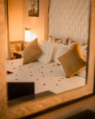 a bedroom with a bed with red flowers on it at Palais Dar Si Aissa ALL-SUITES in Marrakech