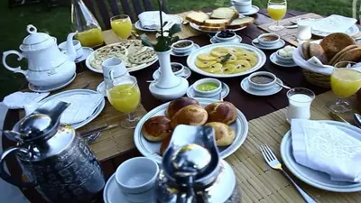a wooden table with plates of food on it at L'OLIVERAIE DE L'ATLAS in Marrakech
