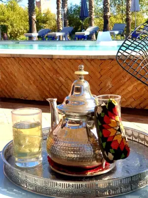a tea pot and a butterfly on a tray with a drink at Casa Taos in Marrakech