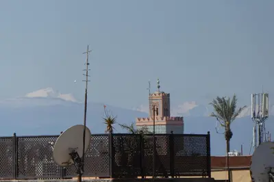 a building with a clock tower behind a fence at Riad Smara in Marrakech