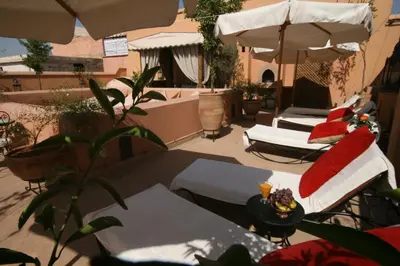 a patio with two lounge chairs and umbrellas at Riad Smara in Marrakech