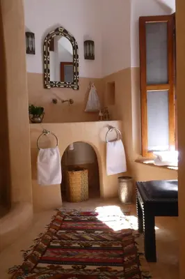 a living room with a fireplace and a mirror at Riad Smara in Marrakech