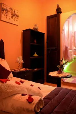a bedroom with a bed and a cabinet and a table at Dar LEULEU in Marrakech