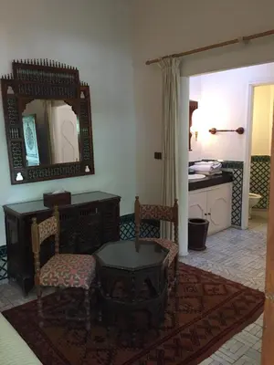 a room with a mirror and a chair and a table at Riad Dar El Assafir in Marrakech