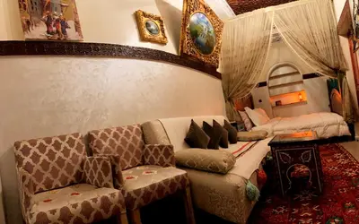 a living room with a couch and a table at Riad Lalla Marrakech in Marrakech