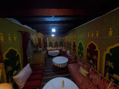 a room with couches and tables in a restaurant at Riad Lalla Marrakech in Marrakech