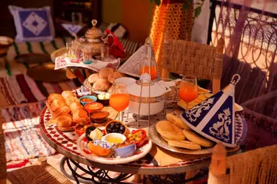 a table with a tray of breakfast foods and orange juice at Riad Lalla Marrakech in Marrakech