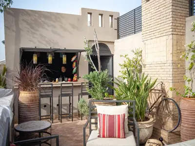 a patio with a bar and some plants at Riad Vanilla Sma & Spa in Marrakech