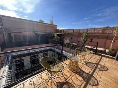 a balcony with a table and chairs on a deck at Riad Ecila in Marrakech
