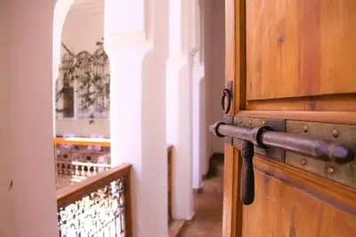 a wooden door with a metal handle in a hallway at Riad Miski in Marrakech