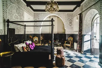 a bedroom with a bed and a chandelier at Riad Dar Jaguar in Marrakech