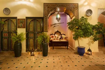 a room with potted plants in front of a bed at Riad Julia in Marrakech