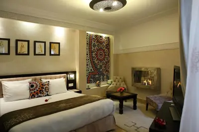 a hotel room with a bed and a fireplace at Riad Monceau in Marrakech