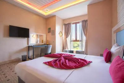 a hotel room with a large bed with a red dress on it at Janat Al Atlas Resort & Spa in Marrakech