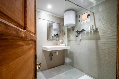 a bathroom with a sink and a toilet and a mirror at Dar Khmissa Riad & Spa in Marrakech