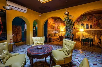 a living room with a table and chairs at Dar Khmissa Riad & Spa in Marrakech