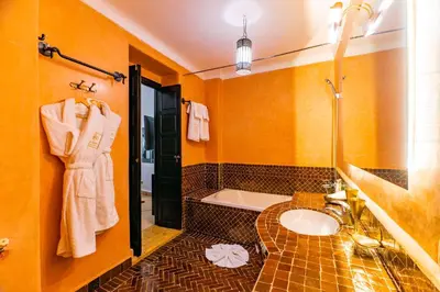 a bathroom with a sink and a bath tub at Riad Dar Dialkoum in Marrakech