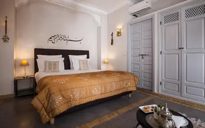 a bedroom with a bed and a door at Riad Shanima SPA Marrakech in Marrakech