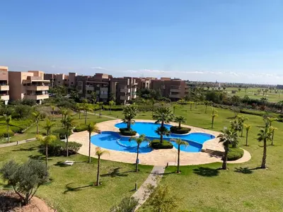 an overhead view of a pool with palm trees and buildings at Appartement à Prestigia Marrakeche avec jardin in Marrakech
