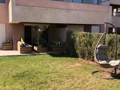 a swing in a yard next to a building at Appartement à Prestigia Marrakeche avec jardin in Marrakech