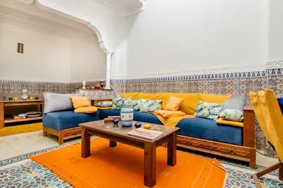 a living room with a blue couch and a table at Riad Medina in Marrakech