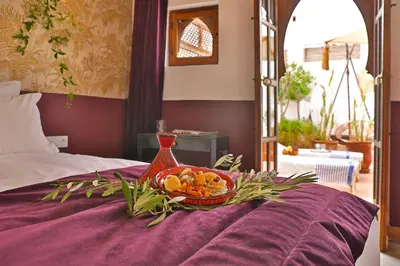 a bowl of fruit sitting on top of a bed at Riad la Parenthèse by Sashema in Marrakech
