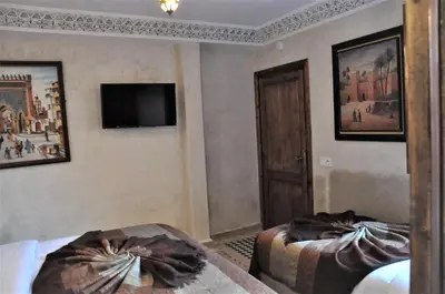 a hotel room with two beds and a mirror at Riad Sania By Ghali in Marrakech