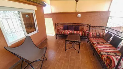 a room with two benches and a table and a window at Riad Abdou in Marrakech