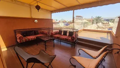 a living room with a couch and chairs and a balcony at Riad Abdou in Marrakech